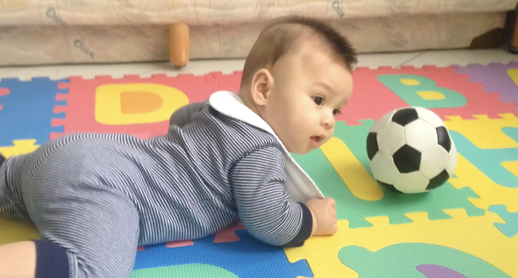 Maddy as a baby with a football